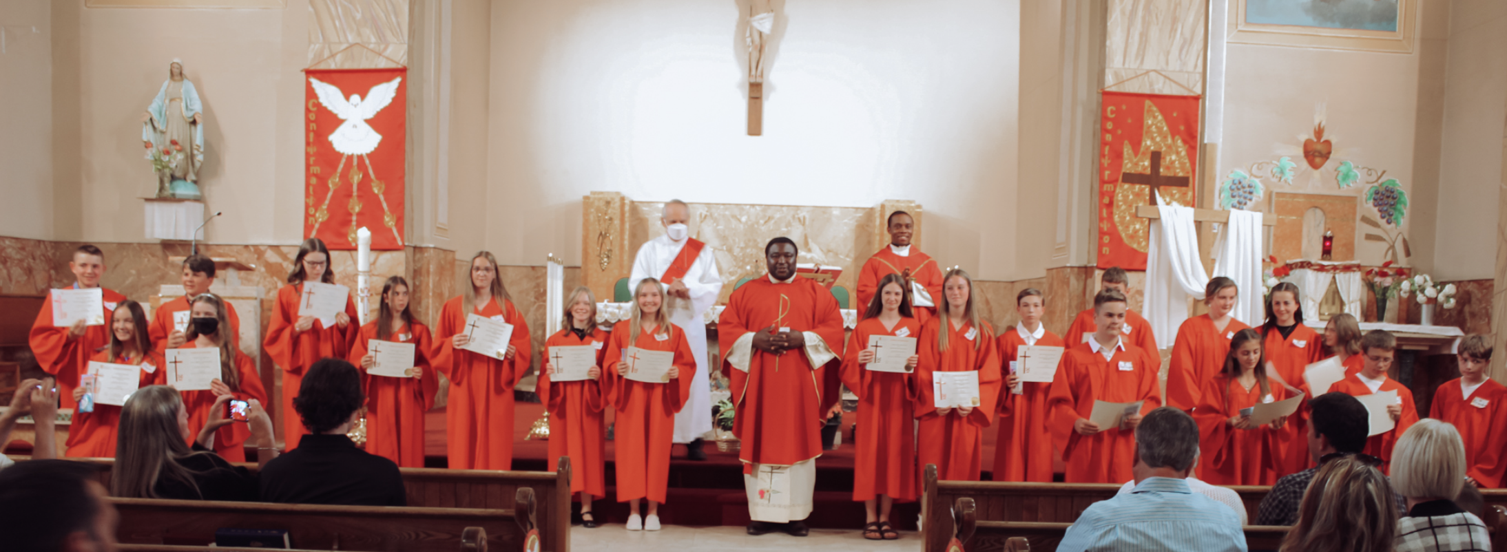 confirmation group photo 2022- confirmandi standing with fr. simon, fr. ben and deacon milton, while holding certificates